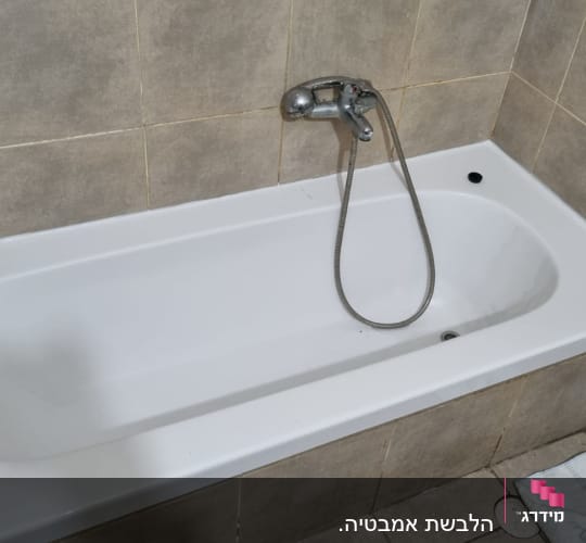 אמבטיה לבנה עם ברז מתכת וקירות מרוצפים